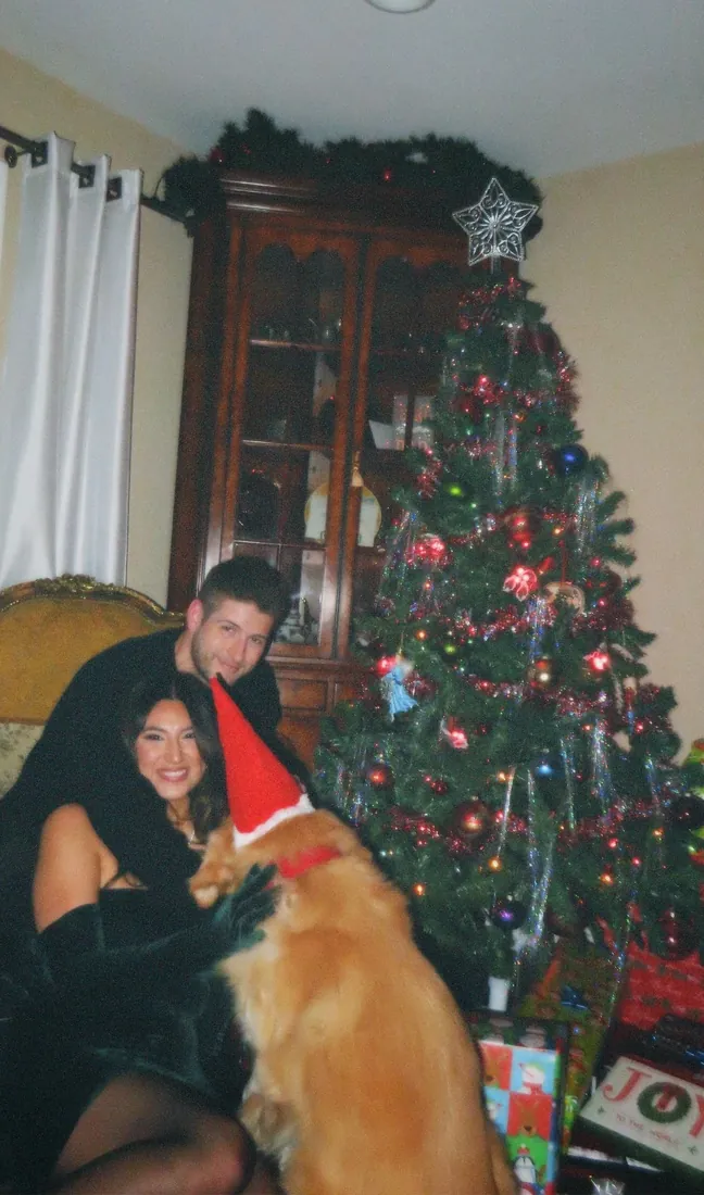 The Crippens with their dog wearing a Santa hat
