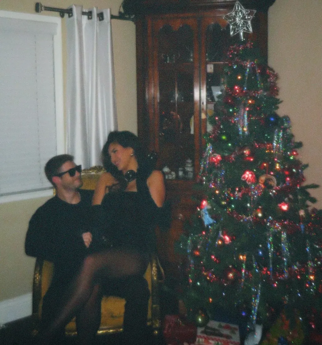 The Crippens seated beside their Christmas tree